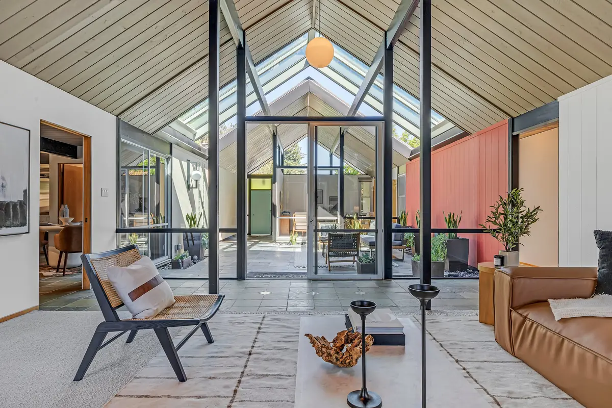 Glass, courtyard, glass, room — four planes deep from one chair.
